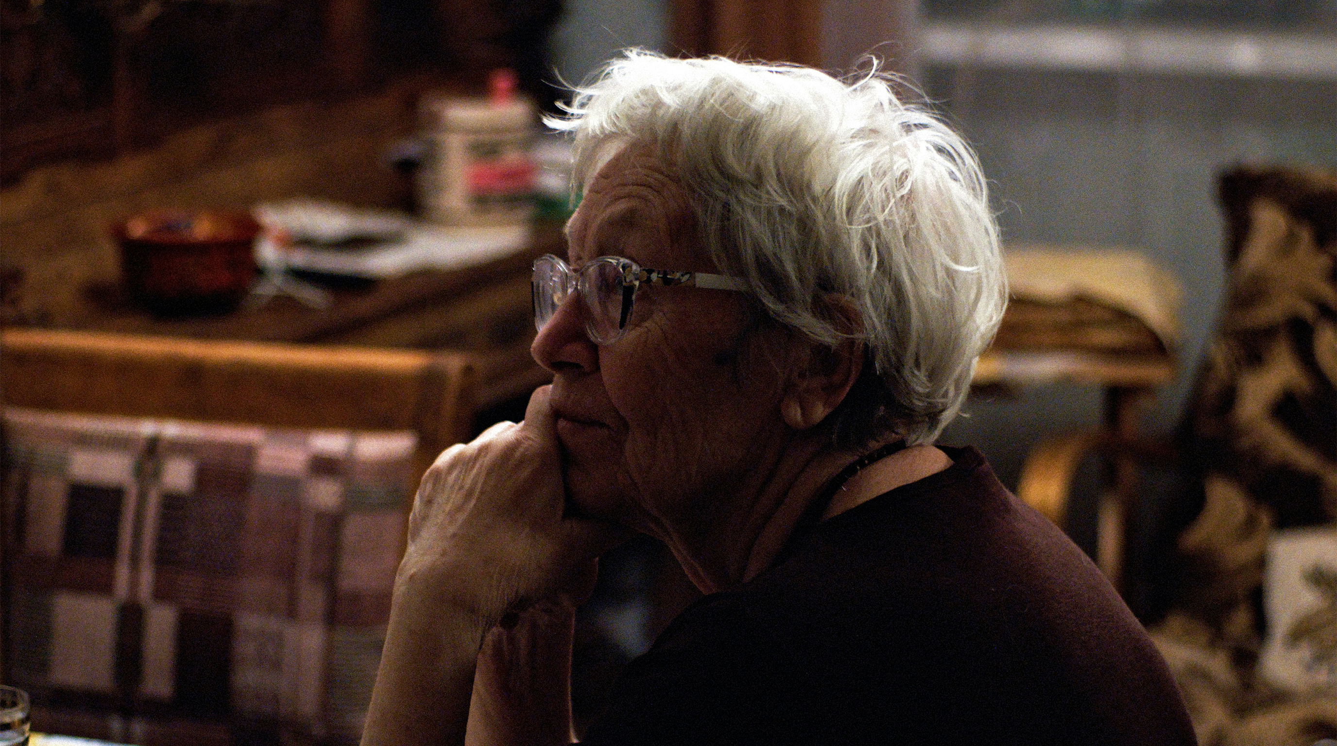 Elderly woman at home, symbolizing aging in place, senior care, and thoughtful moments during daily life.